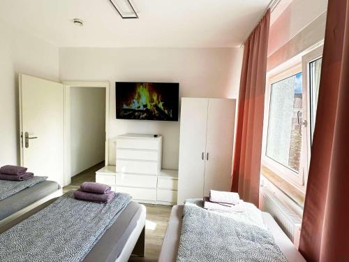 a bedroom with two beds and a tv on the wall at Gemütliche Apartments in Herten in Herten