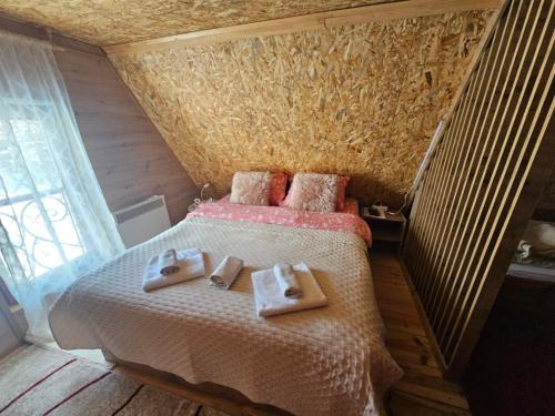 a bedroom with a bed with two towels on it at Kod Gruja in Ribnica