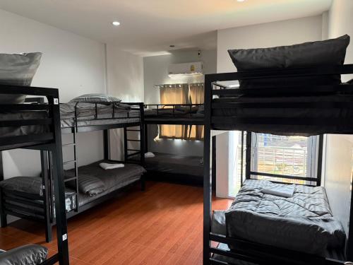 a room with four bunk beds in a dorm room at Lunar Nomad Hostel in Ban Nua