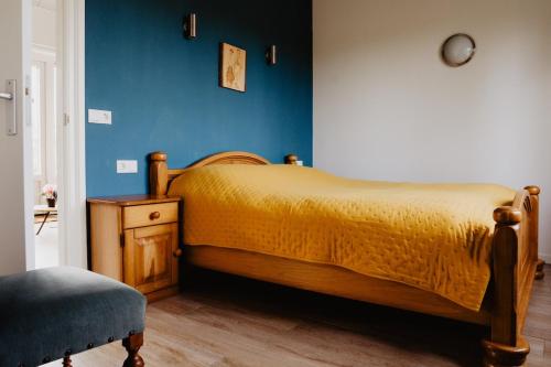a bedroom with a bed and a blue wall at Huize Henk in Emst