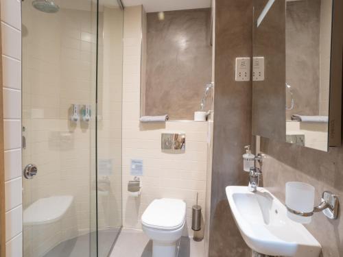 a bathroom with a toilet and a sink and a shower at Birgu Seafront 3 Bedroom Apartment in Vittoriosa