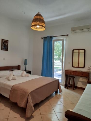 a bedroom with a bed and a mirror and a window at Riverside Αpartments in Vasiliki