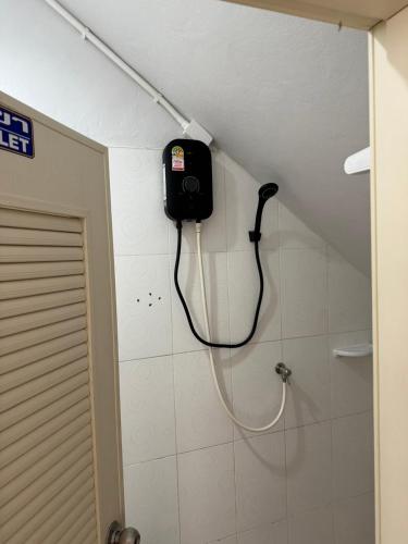 a shower in a bathroom with a hose on the wall at Lunar Nomad Hostel in Ban Nua