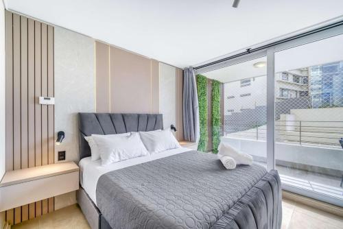 a bedroom with a large bed and a large window at Eluchans One with Pool & parking near Reñaca Beach in Viña del Mar