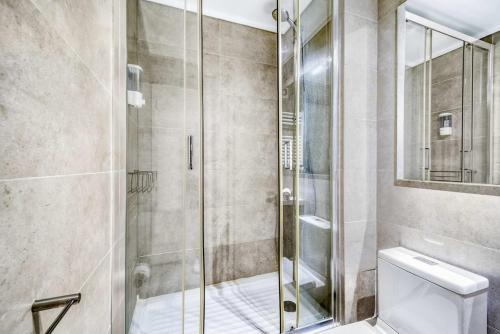a shower with a glass door in a bathroom at Eluchans One with Pool & parking near Reñaca Beach in Viña del Mar