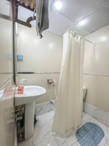 a bathroom with a shower curtain and a sink at World Inn by WIH in Karachi