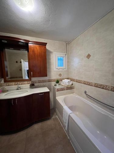a bathroom with a bath tub and a sink at Rida Sultan Konağı Kozbeyli in Eskiömerler