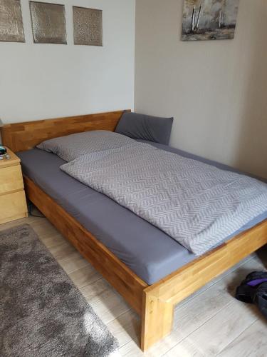 a bed with a wooden frame in a room at Omas Stübchen - Monteurwohnung auf dem Land in Borken