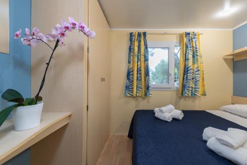 a bedroom with two towels on a blue bed at Camping Villaggio Il Pilone in Rosa Marina