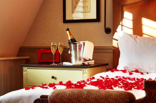 a bed with a bottle of champagne and two glasses at King Street Townhouse Hotel & Spa in Manchester