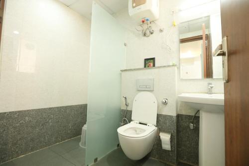 a bathroom with a white toilet and a sink at CORPORATE STAYS-Golf Course Road in Gurgaon