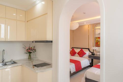 a kitchen and a bedroom with a bed and a sink at Bailey Hotel Hue in Hue
