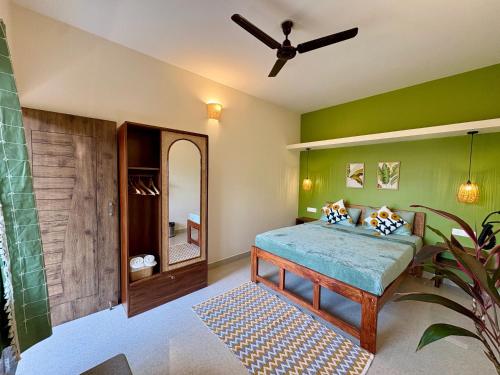 a bedroom with a bed and a ceiling fan at The Habitat By Locomo in Mandrem