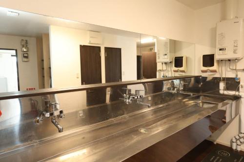 a kitchen with a row of sinks and mirrors at バーニングハーツ in Asahikawa
