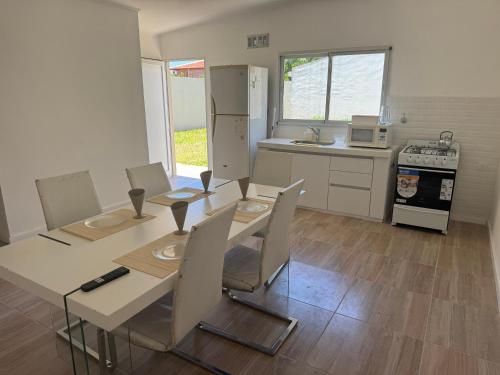 a kitchen with a table and chairs and a kitchen with a refrigerator at Ms3M casa in San Pedro