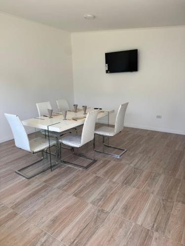a conference room with a table and chairs and a flat screen tv at Ms3M casa in San Pedro