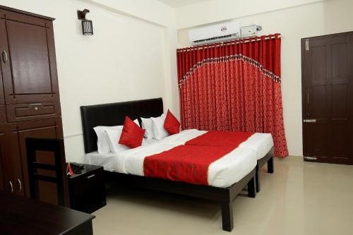 a bedroom with a bed with a red curtain at Hotel O Technopark Formerly Le Frank in Trivandrum