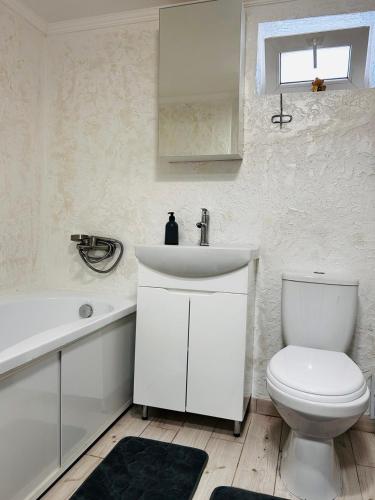 a bathroom with a white sink and a toilet at Книжка in Vinnytsya