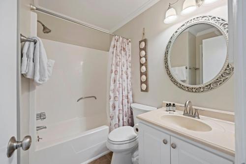 a bathroom with a sink and a toilet and a mirror at SC217A: 217A Sea Cabin in Isle of Palms