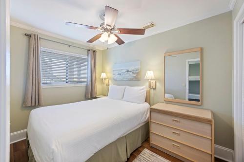 a bedroom with a white bed and a ceiling fan at SC217A: 217A Sea Cabin in Isle of Palms