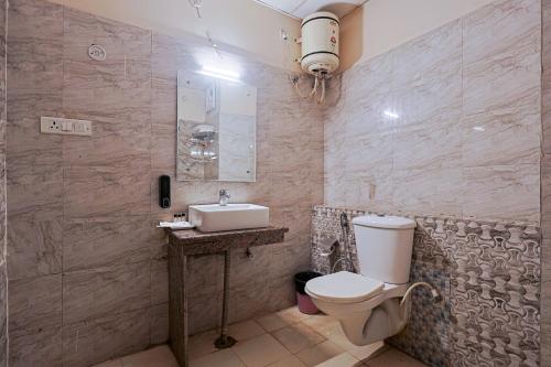 a bathroom with a toilet and a sink at Hotel Leaf Inn in Lucknow