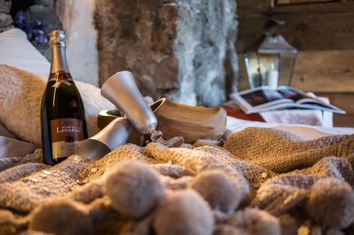 a bottle of wine sitting next to a pile of bread at Maison La Saxe in Courmayeur