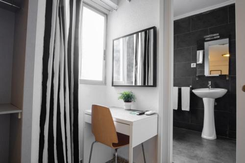 a bathroom with a white desk and a sink at Hostal On Dormire Valencia in Valencia