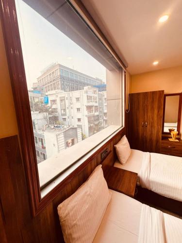 a bedroom with a large window with a view of a city at Hotel Windsor Plaza in Hyderabad