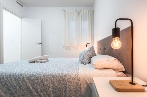 a bedroom with a bed and a lamp on a table at Algaba Huelva alto in La Algaba