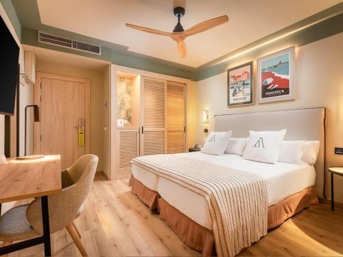a bedroom with a bed and a desk and a television at ARTIEM Capri in Mahón