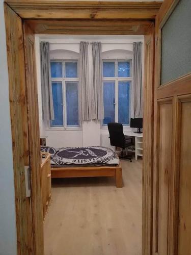 a bedroom with a bed and a desk and windows at Studio Appartement without steps and terrace in Görlitz