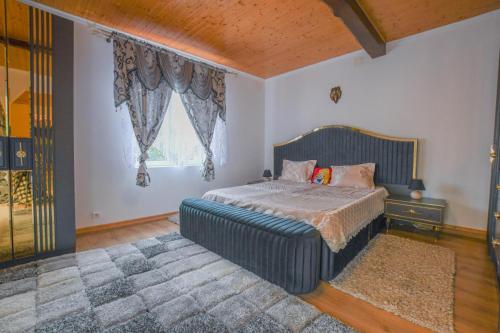 a bedroom with a bed and a large window at La lukas in Mussy-sur-Seine