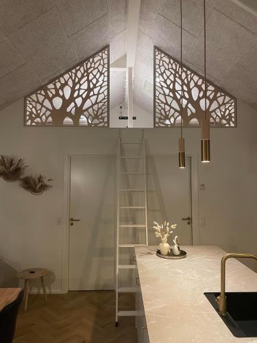 a kitchen with a table and two trees on the wall at Feriehus 1147 in Ringkøbing