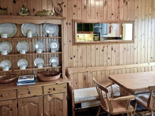a dining room with a table and plates on the wall at Hen Ysgol in Llanfaethlu