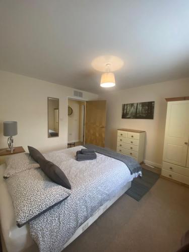 a bedroom with a large bed and a dresser at Childes Court in Nuneaton