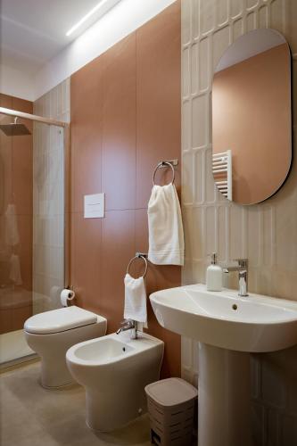 a bathroom with a sink and a toilet and a mirror at VenereCiprea in Castelbuono