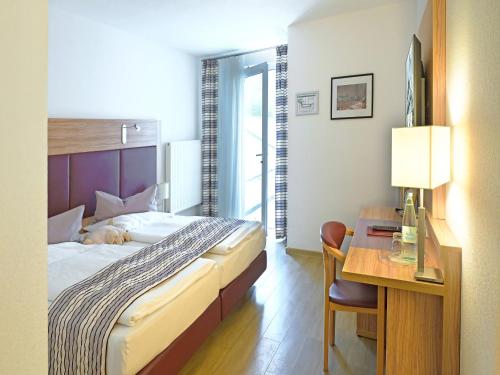 a bedroom with a bed and a desk with a desk at Hotel Kronprinz in Bad Salzdetfurth