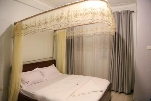a bedroom with a bed with a canopy at JD LUXURY HOTEL Jinja in Jinja