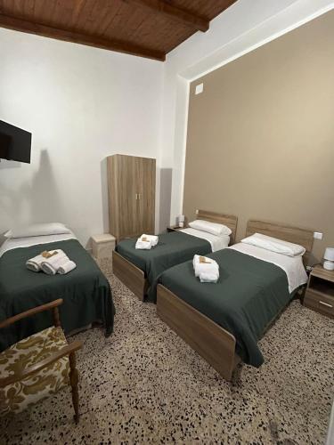 a room with two beds with towels on them at Casa Bel Duomo in Gerace
