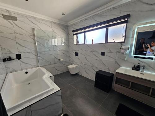 a bathroom with a tub and a sink and a mirror at Pegasus Peak Lodge in Drummond