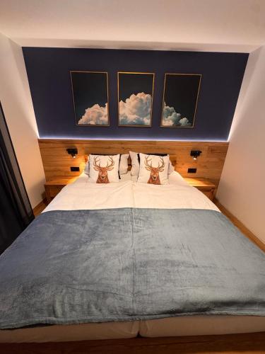 a bedroom with a large bed with three pictures on the wall at Haus Orion in Eupen