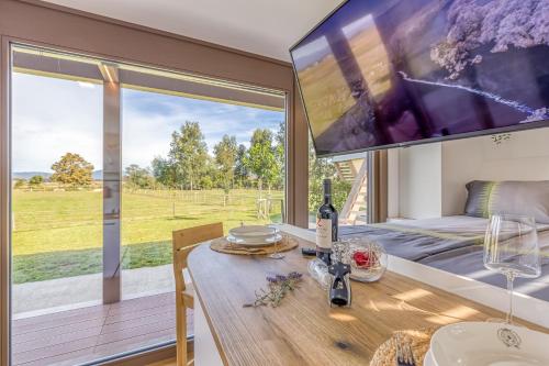a room with a table and a large tv on the wall at Riverside Suite Mobile Homes in Gradac