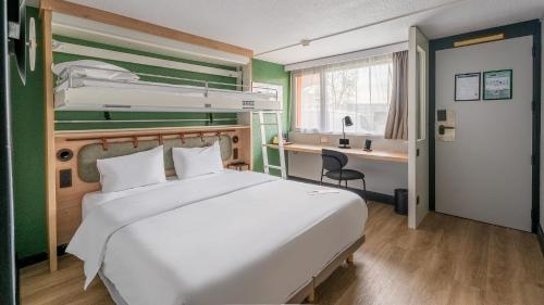 a bedroom with a bed and a desk and a bunk bed at Campanile NATURE - Bordeaux Lac in Bordeaux