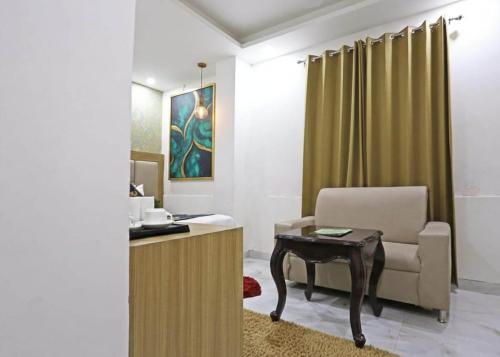 a living room with a chair and a table at Hotel Decent Suites - Delhi Airport in New Delhi