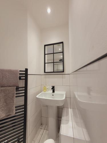 a white bathroom with a sink and a bath tub at Ideal Lodgings in Radcliffe in Radcliffe