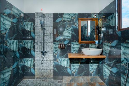 a bathroom with a sink and a mirror at Evergreen Villa - Sinharaja in Deniyaya