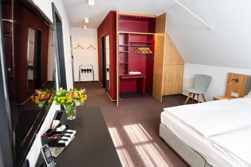 a hotel room with a bed and a table with flowers at Hotel Kloster Eberbach in Eltville