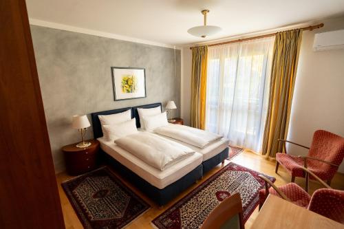 a hotel room with a bed and a window at Pension Christina in Weiz