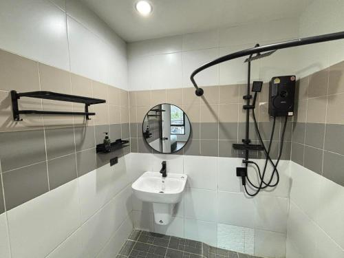 a bathroom with a sink and a mirror at Atrium Kathu Hotel in Ban Kathu (1)