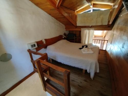 a bedroom with a bed in a room with wooden floors at Complejo El Alto in Tanti
